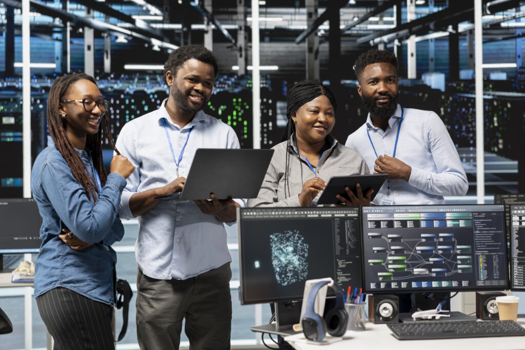 Cheerful data center experts working together, using deep learning algorithms and node trees to analyze datasets. Jolly server farm teamworking colleagues using AI to recognize facility data patterns